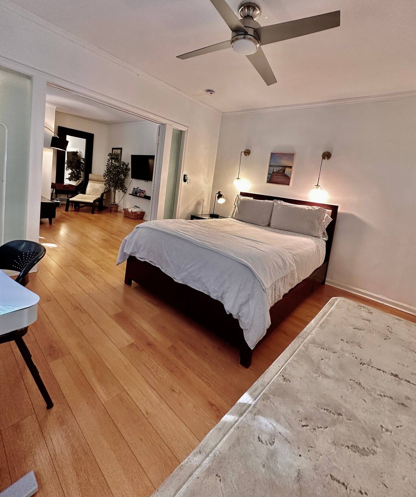 Front bedroom with queen bed, ceiling fan and rug