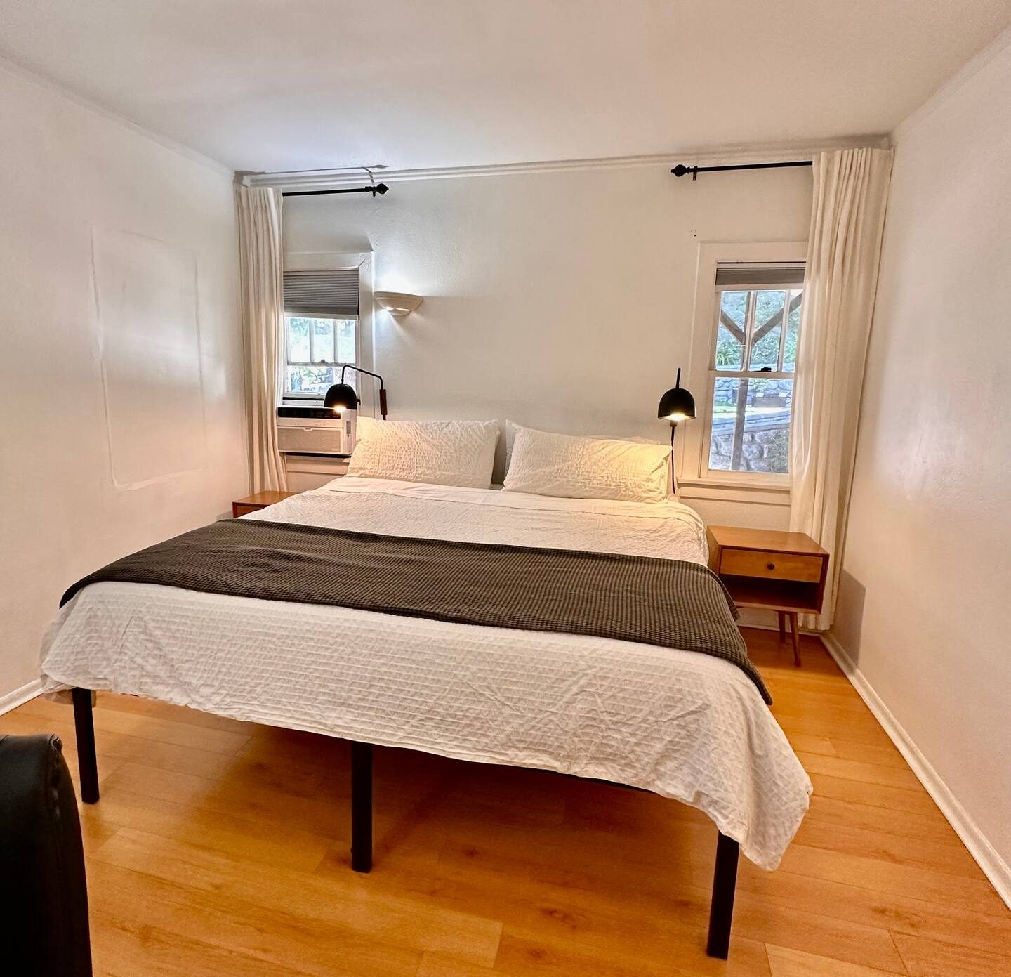 Back bedroom with king bed and white linens under two windows