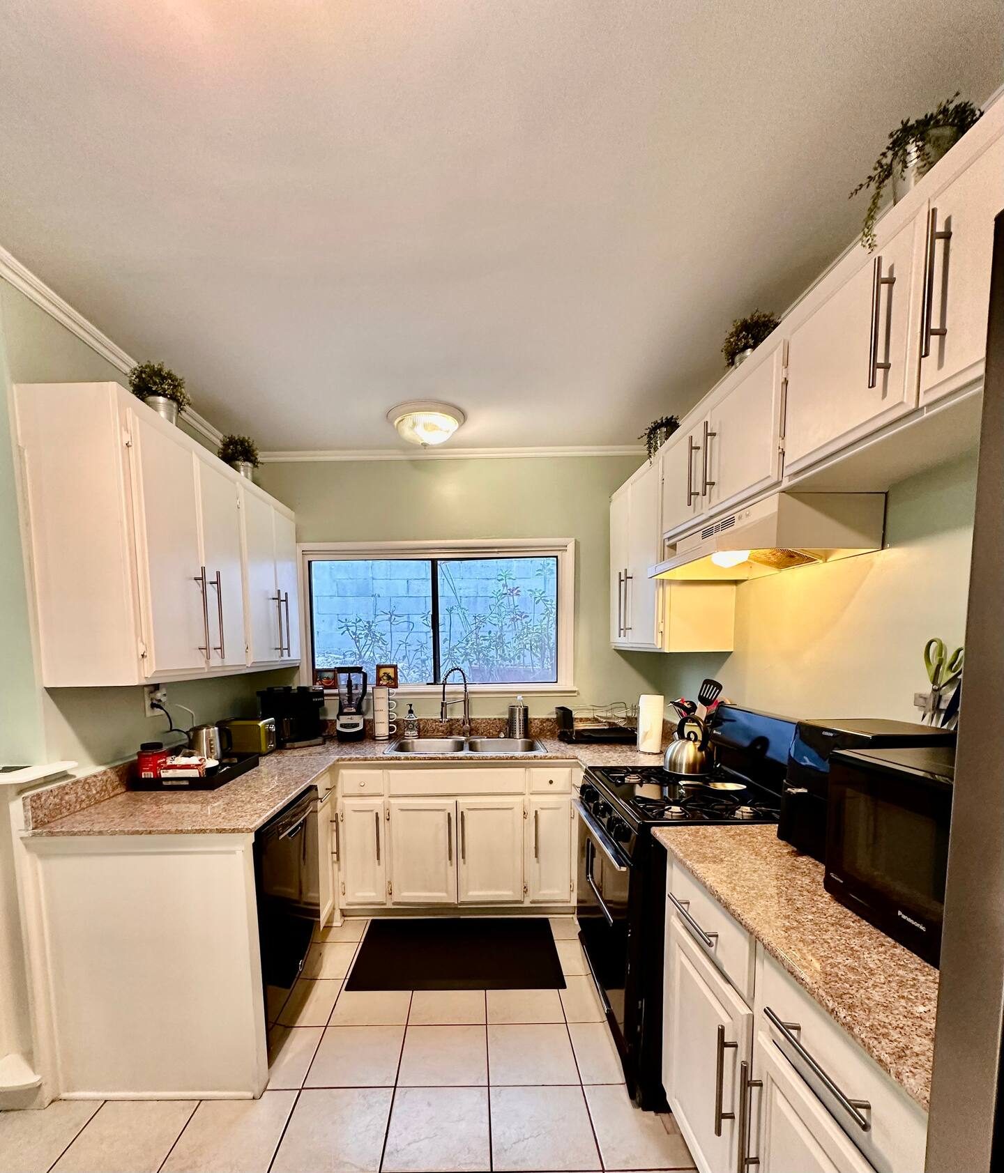 The kitchen, white cabinets, granite counter, gas stove