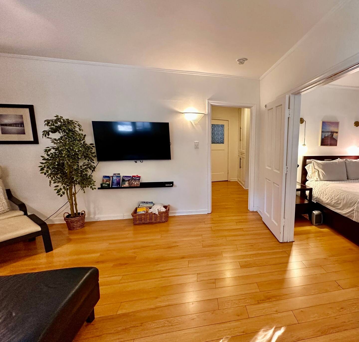 The living room, leather sofas and honey oak floors, TV on the wall