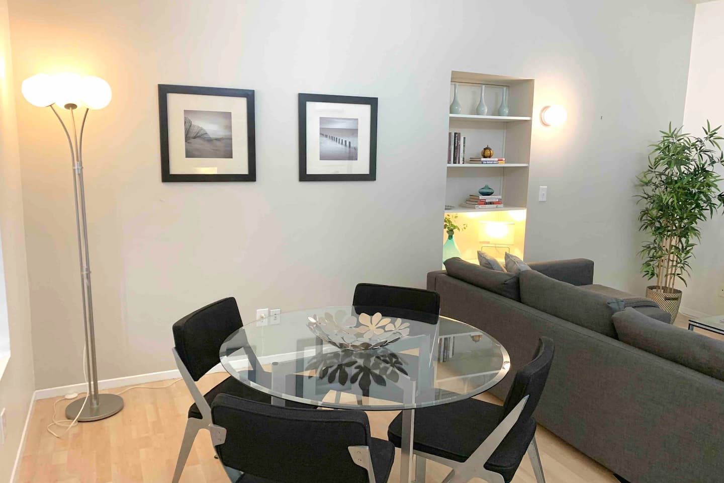 Glass dining table and grey sofa in the studio living area