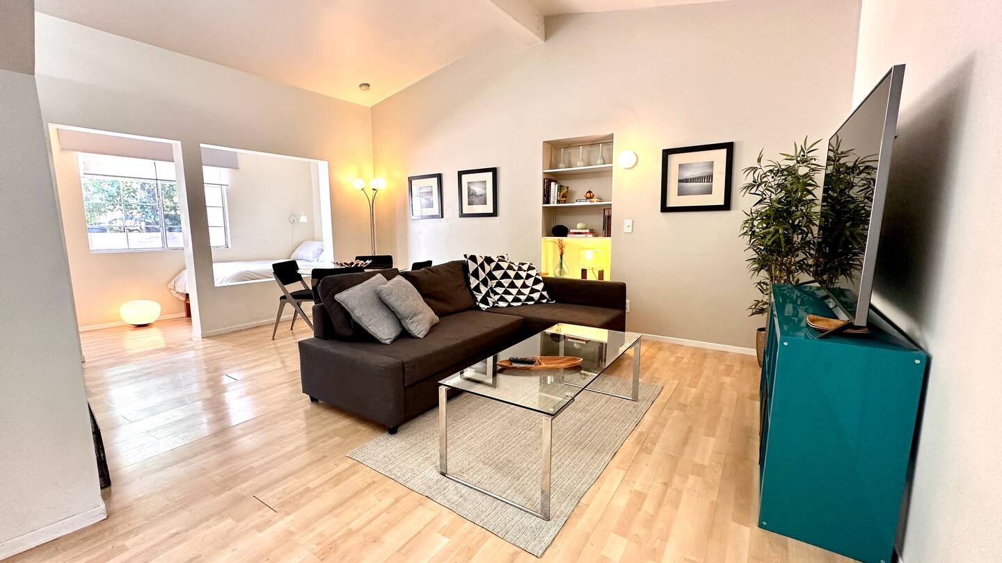 The studio living area toward the window nook, teal cabinet and TV